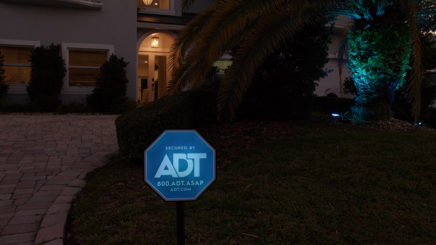 A real Indianapolis-area home at dusk, protected by an ADT Live Light yard sign