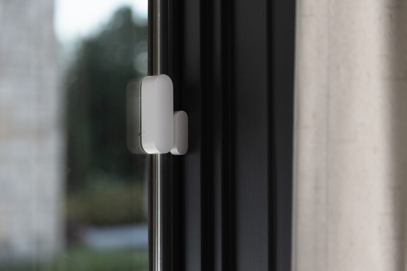 An ADT door and window sensor mounted on a home's window